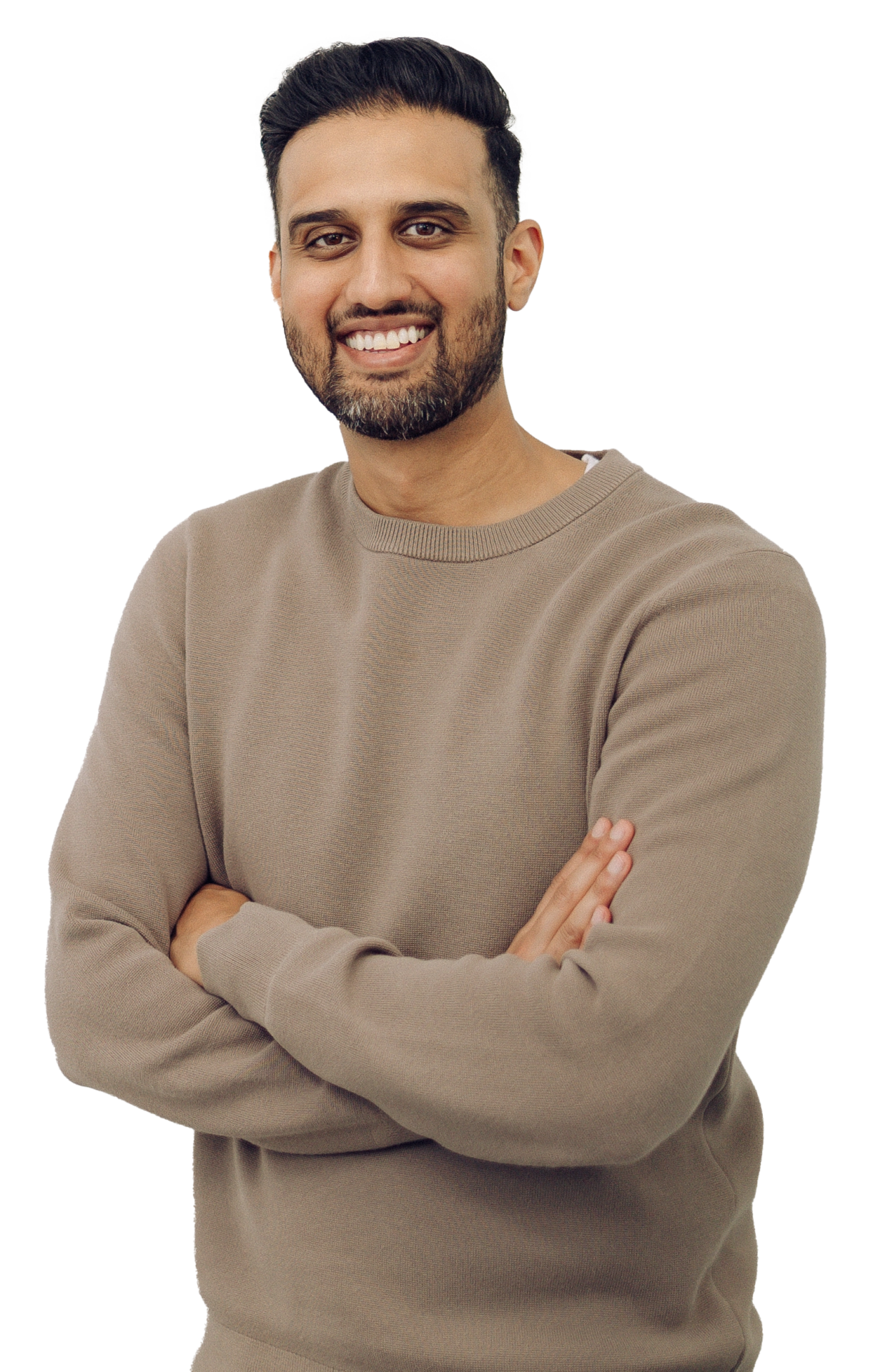 A person with crossed arms, smiling, wearing a beige sweater against a plain background.